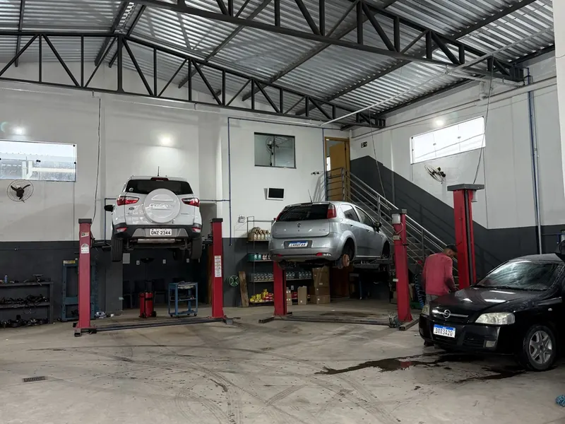 Galpão da MG Autocenter em Lavras com carros sobre os elevadores